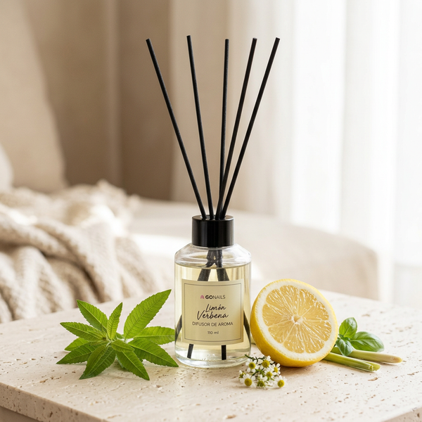 Difusor de varillas Limón Verbena sobre travertino, con limones frescos, hojas de verbena y hierbas verdes. Frasco de vidrio 110 ml, Go Living.